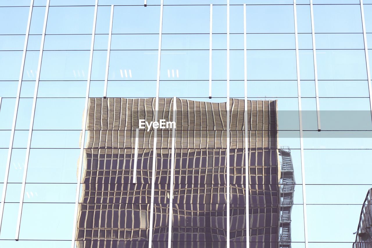 Low angle view of glass building against sky