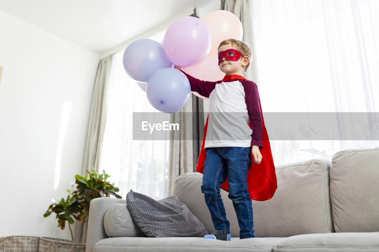 rear view of woman with balloons in living room