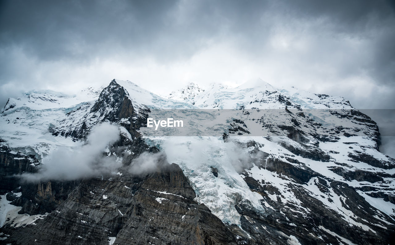 SNOW COVERED MOUNTAINS AGAINST SKY