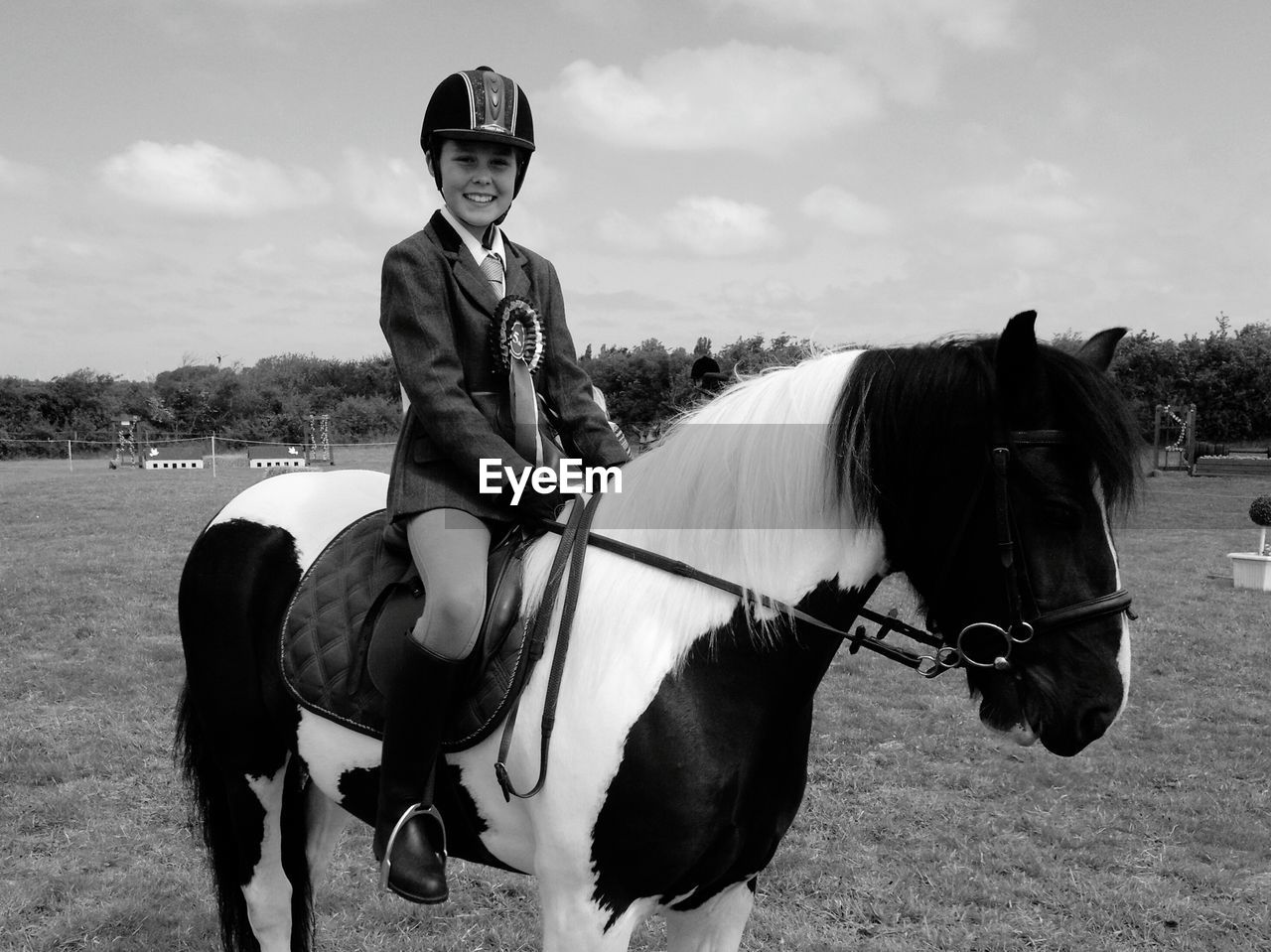 Portrait of smiling woman sitting on horse against sky