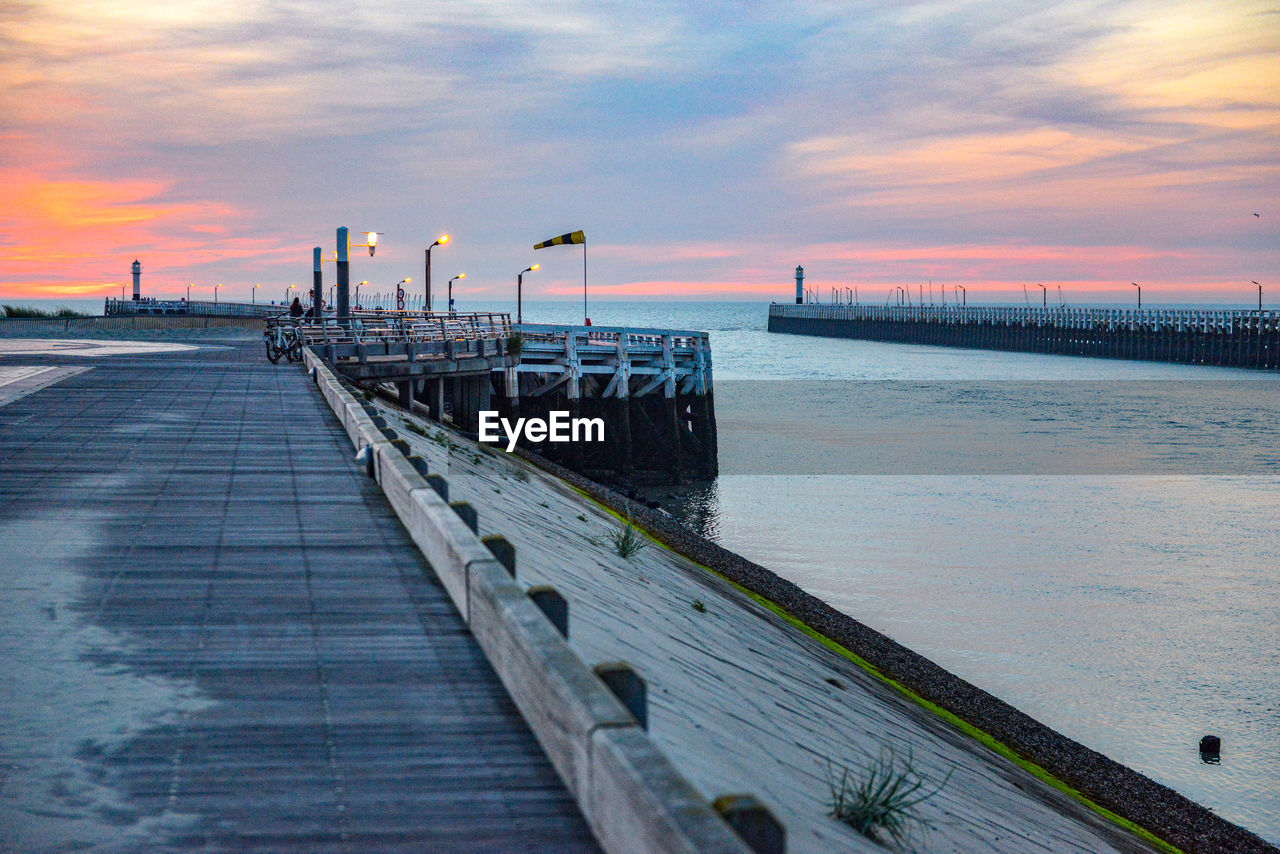 Pier over sea against sky during sunset