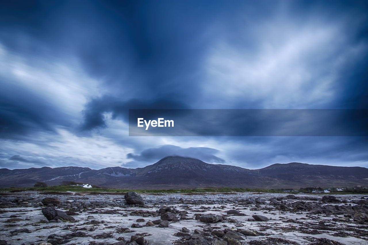 Scenic view of mountains against cloudy sky