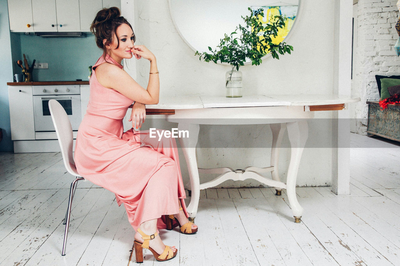 Glamorous woman sitting on chair at home