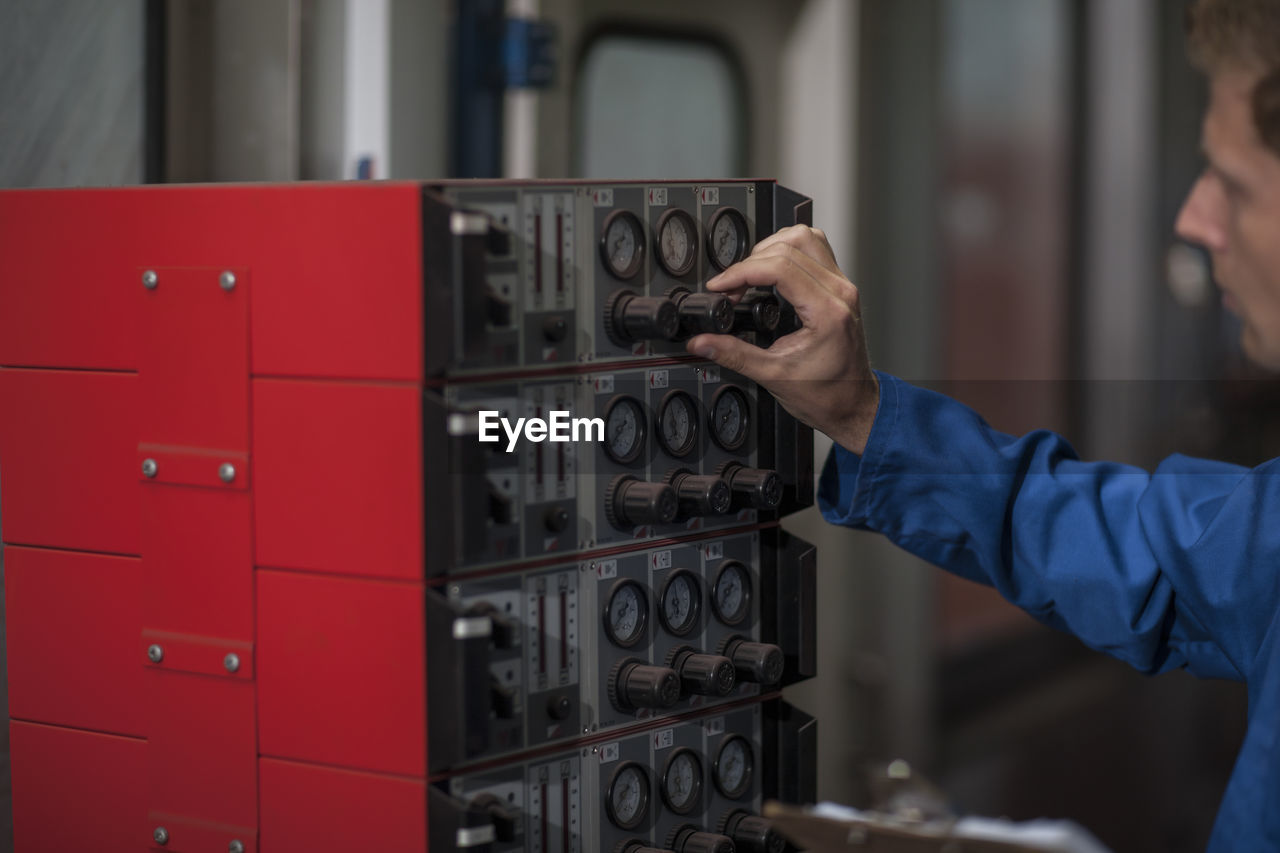 Factory worker in truck manufacture operating control panel