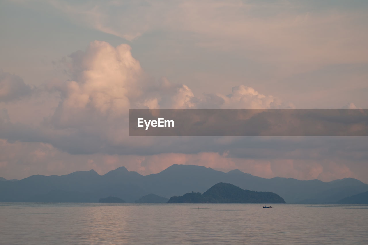 Scenic view of lake by mountains against sky