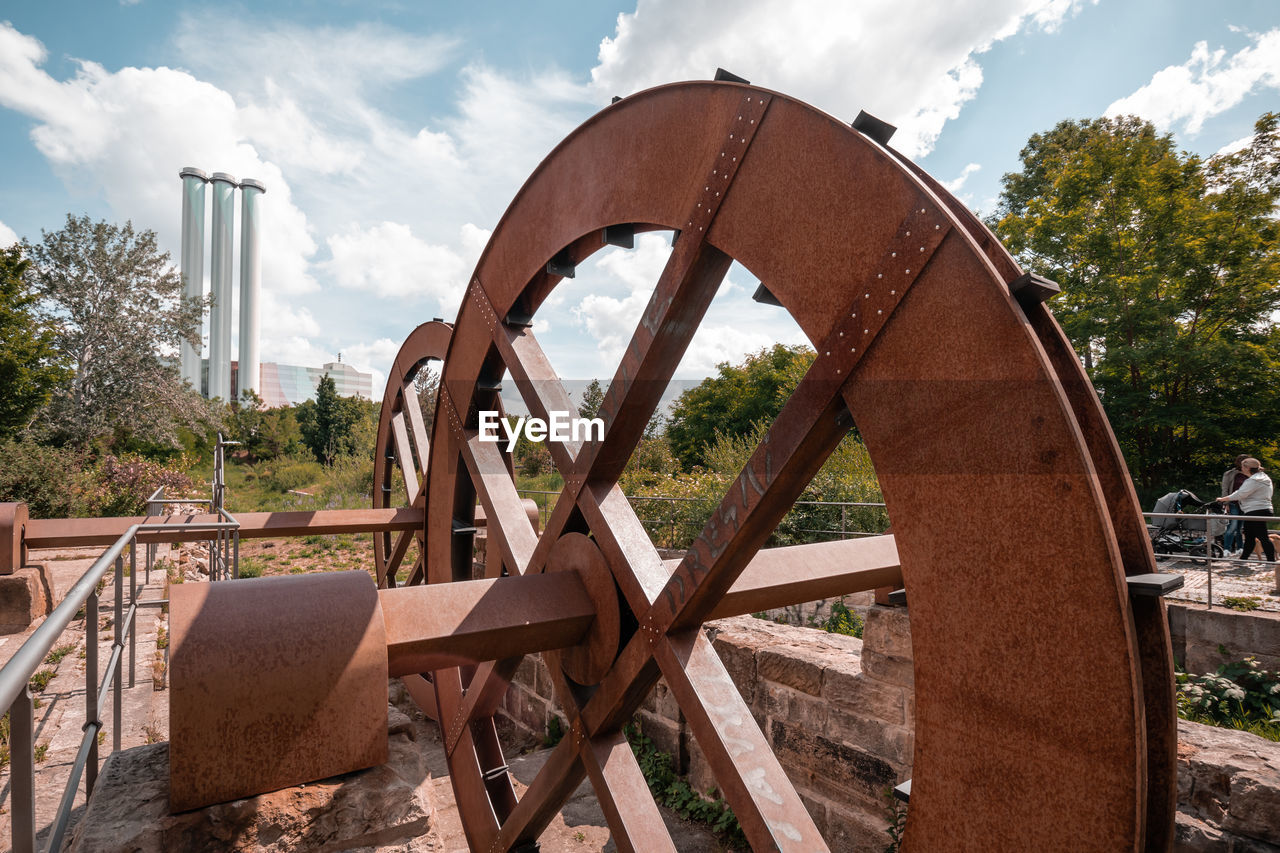 Rusty metallic structure on field against sky