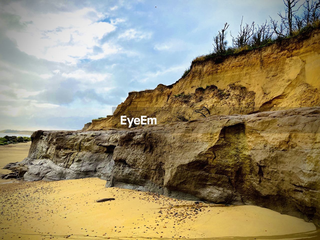 Low angle view of rock formation on beach against sky