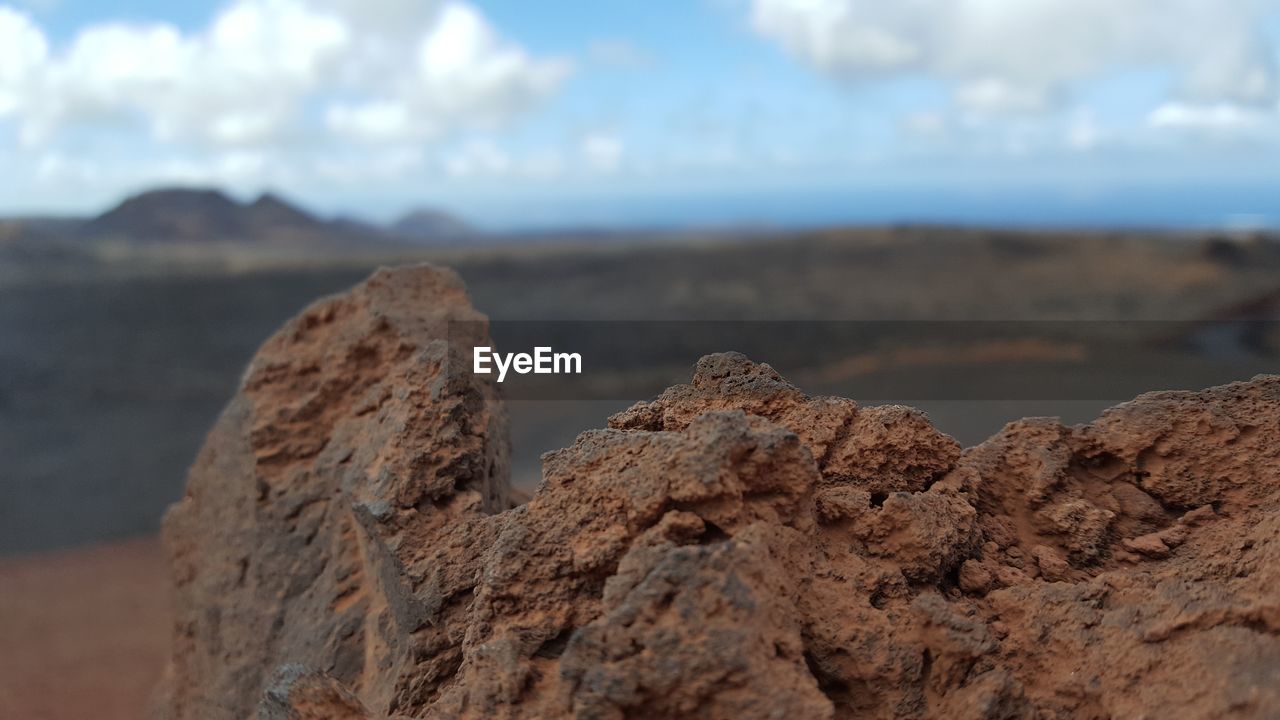 Close-up of rock formation on beach against sky