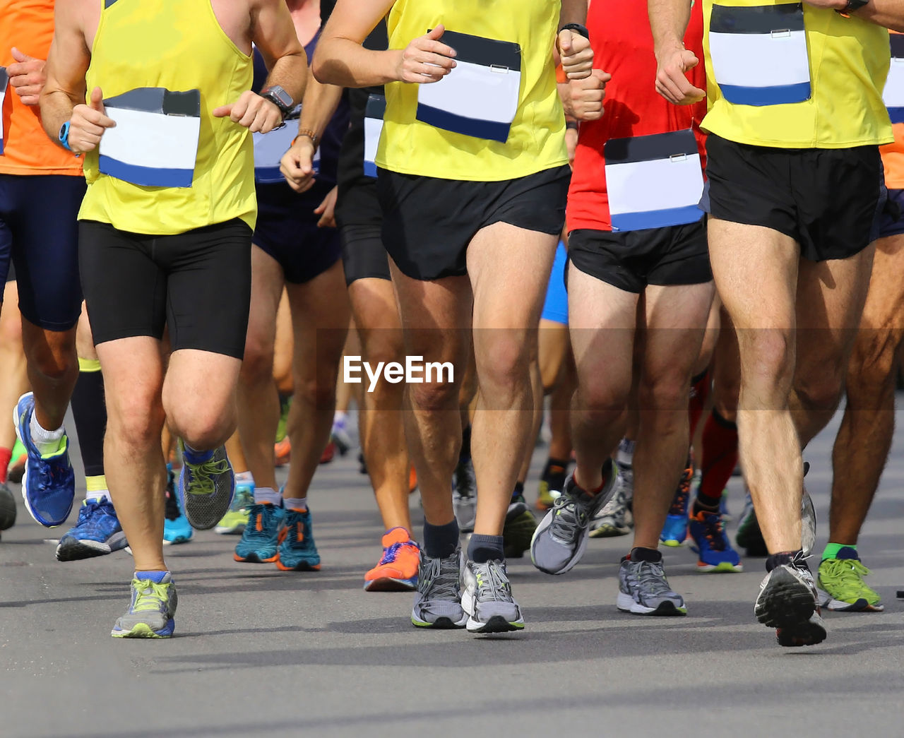 LOW SECTION VIEW OF PEOPLE RUNNING AT STADIUM