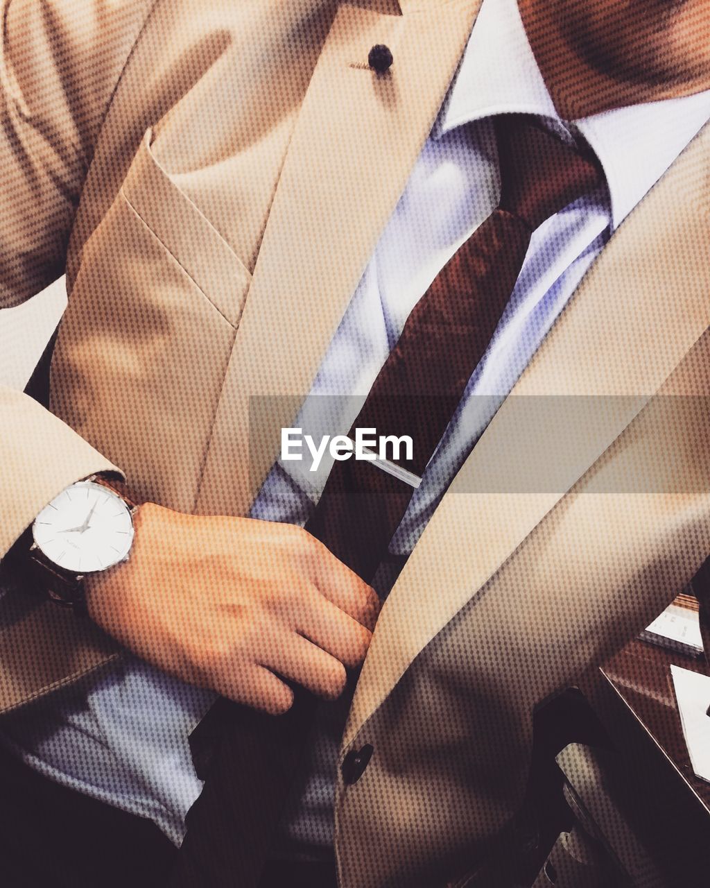 Midsection of businessman holding necktie