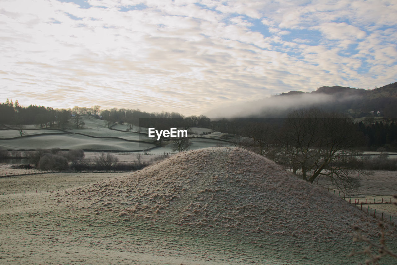 VIEW OF FROZEN LAKE AGAINST SKY