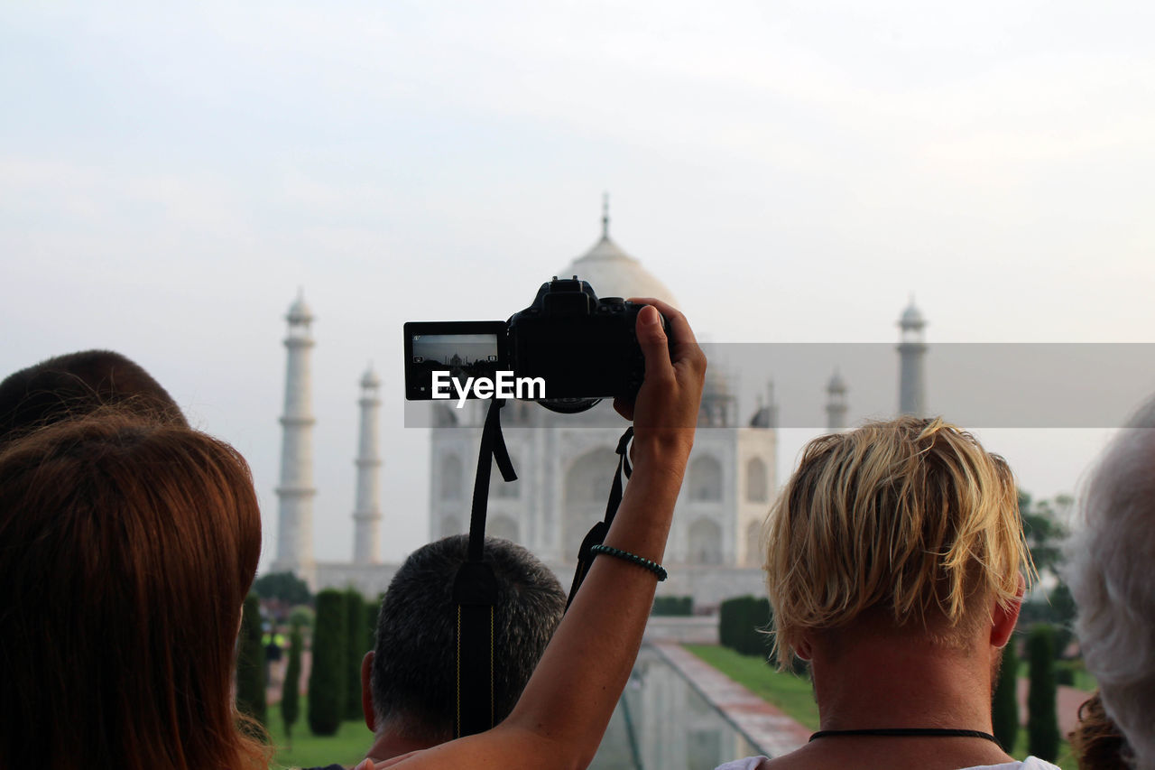 REAR VIEW OF WOMAN PHOTOGRAPHING WITH CAMERA