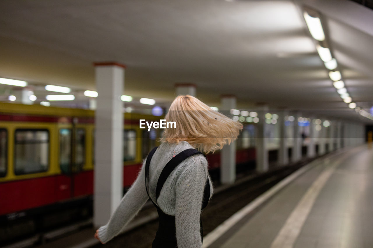 Side view of woman standing at railroad station platform