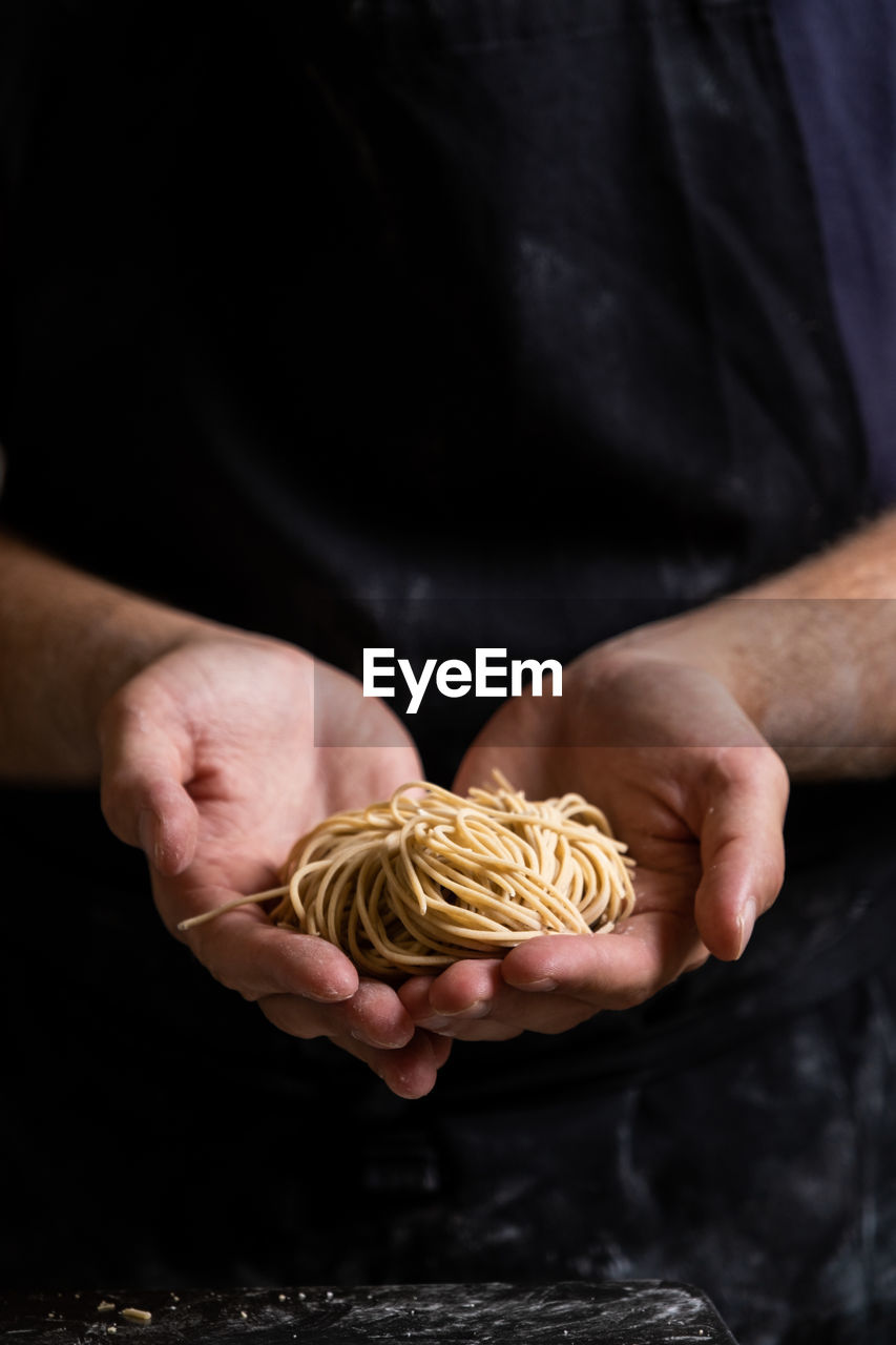 Cropped hand of man holding ramen noodles 