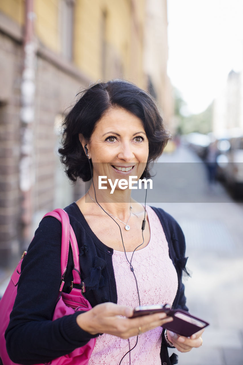 Smiling mature woman with earphones