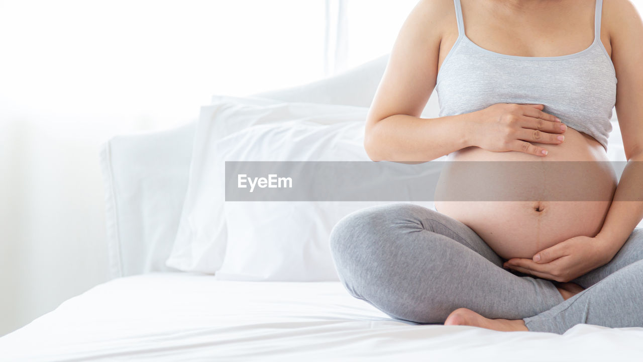 MIDSECTION OF WOMAN LYING IN BED