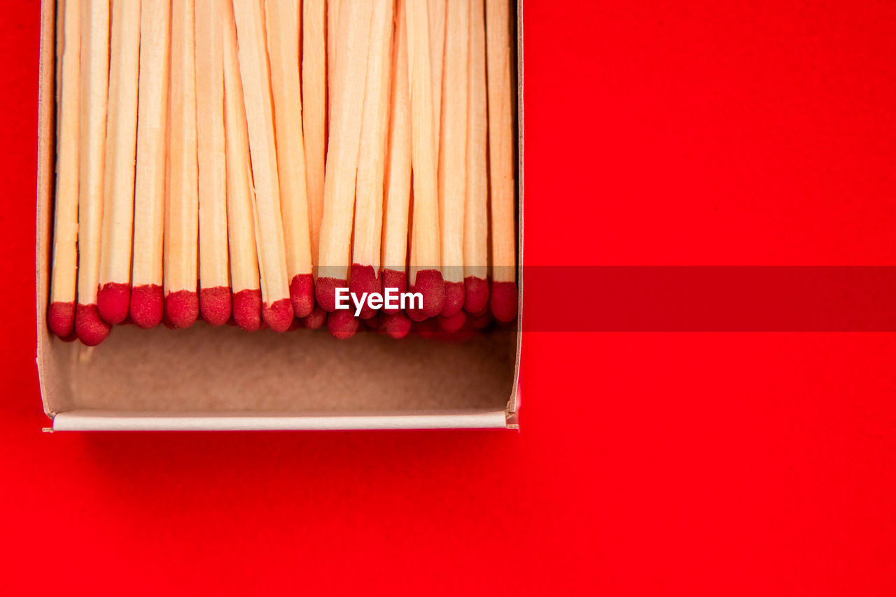 HIGH ANGLE VIEW OF PENCILS ON RED TABLE