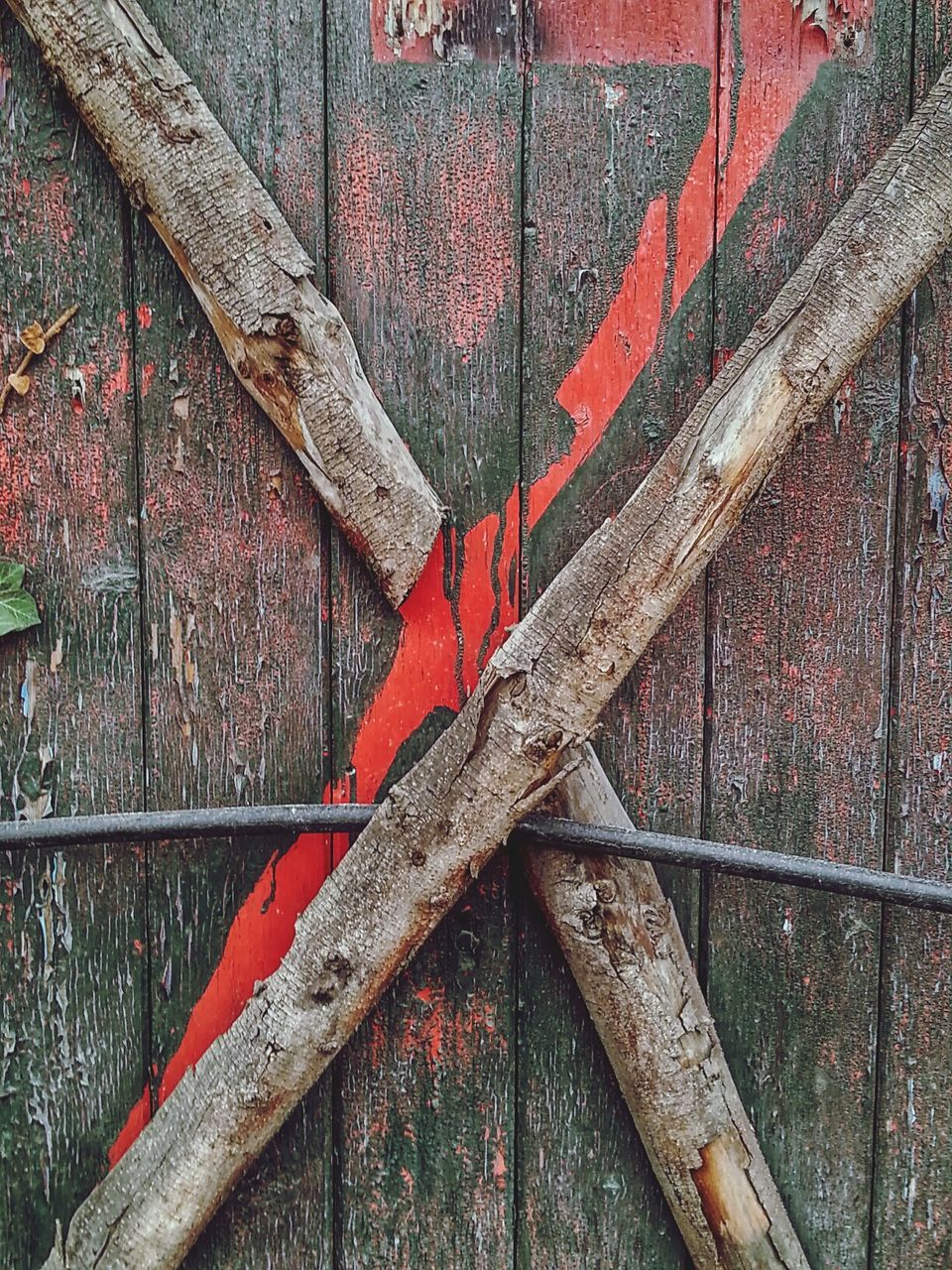 Cross logs against wooden fence