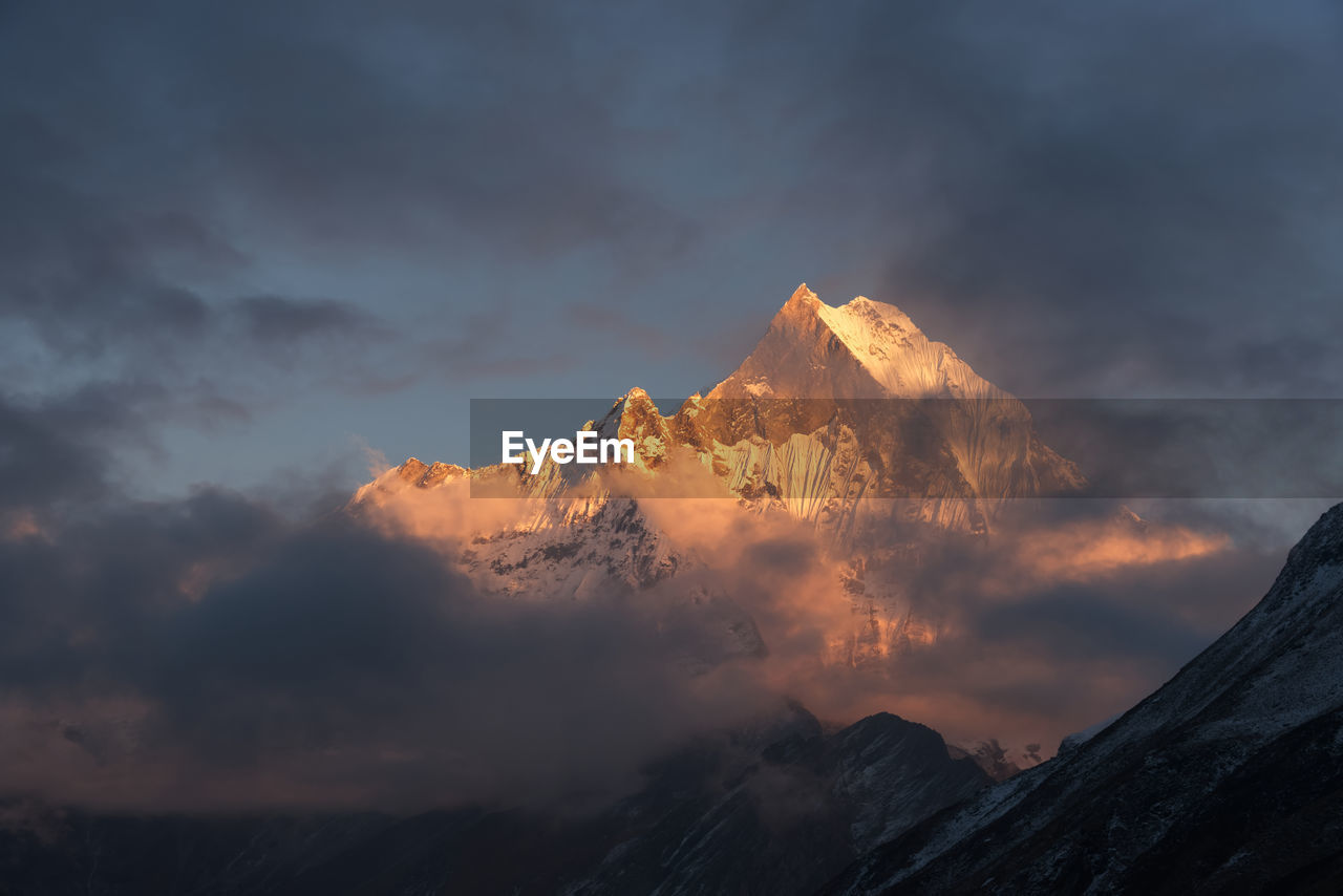 Low angle view of snowcapped mountains against sky during sunset