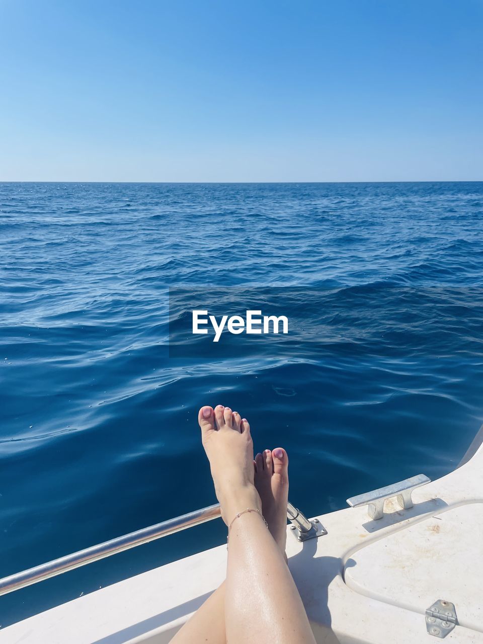 Low section of woman swimming in sea on a boat