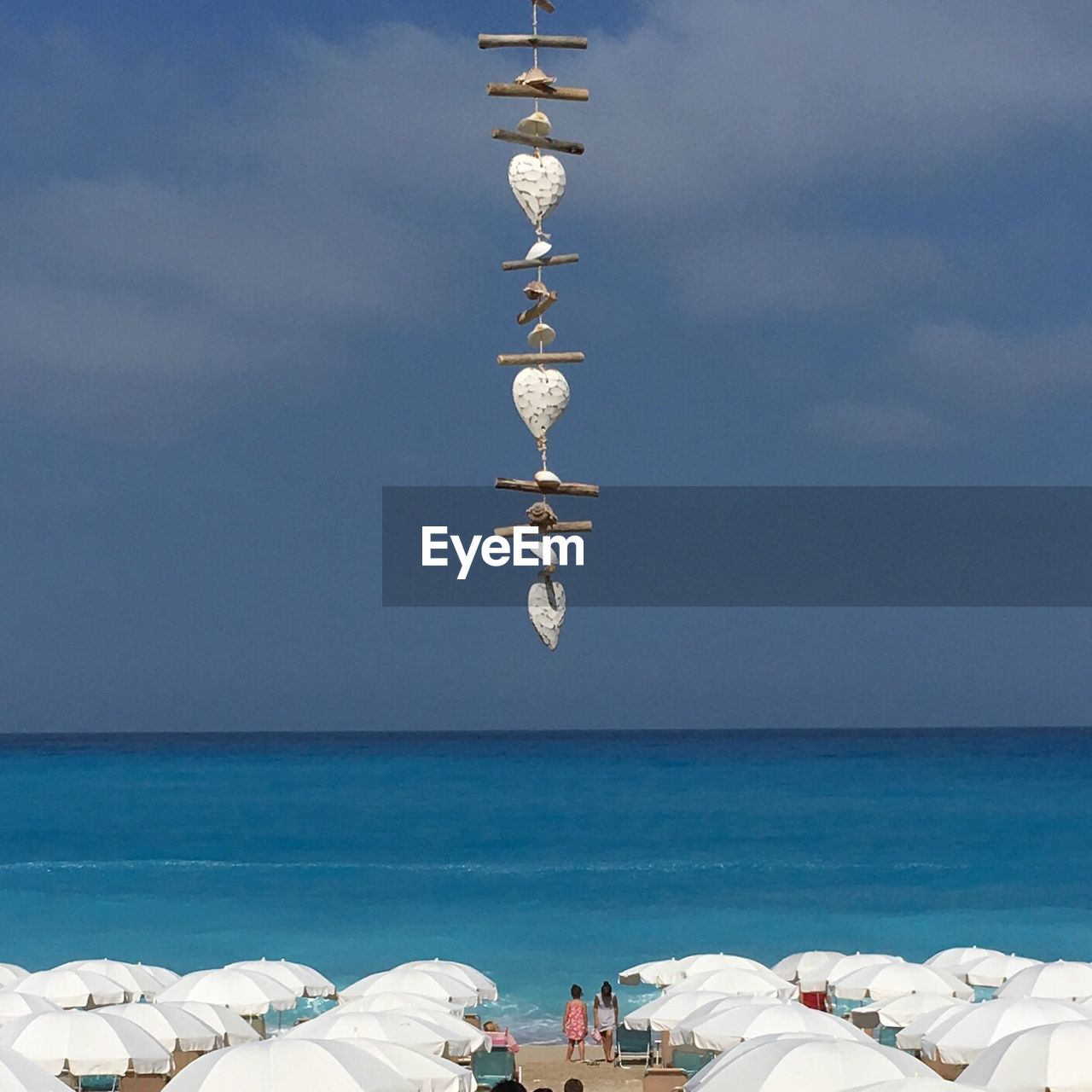Close-up of decor hanging over beach against sky
