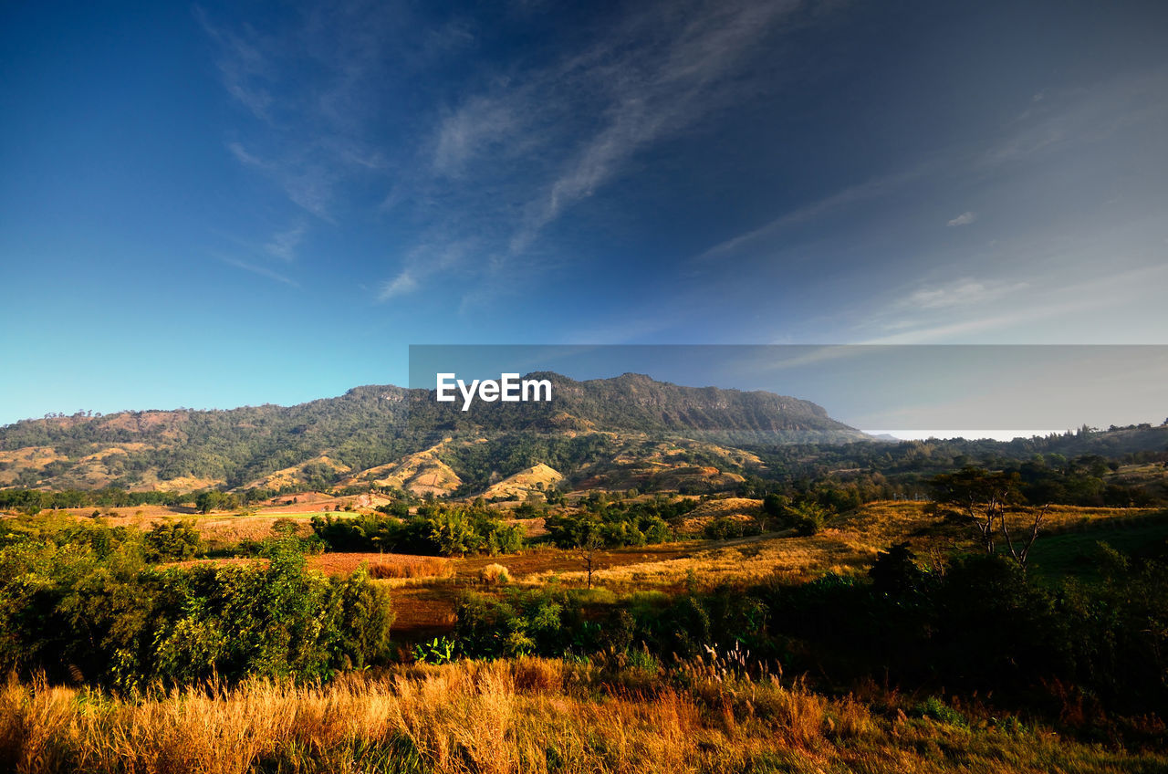 Scenic view of mountains against blue sky