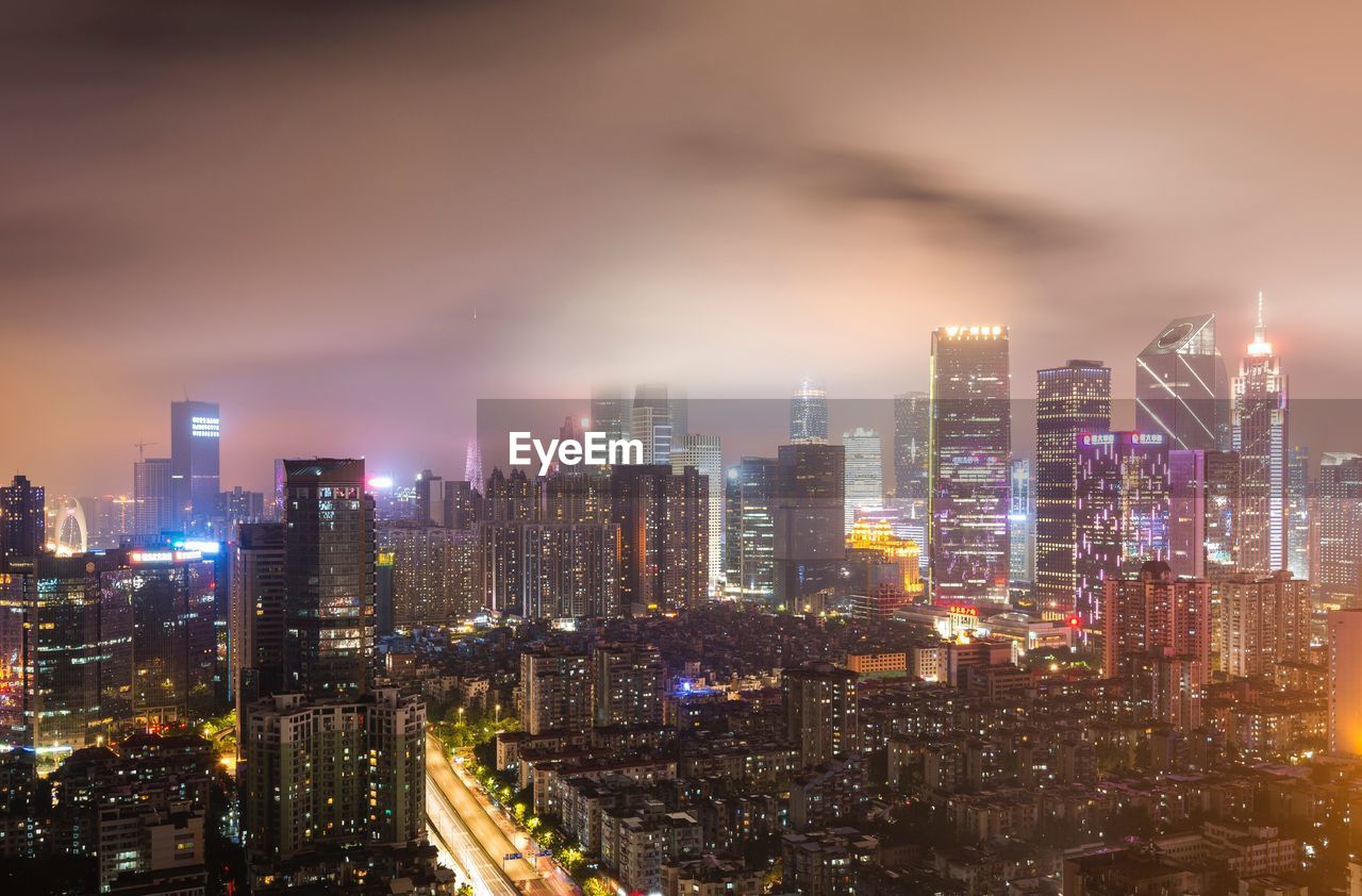 Illuminated buildings in city against sky at night