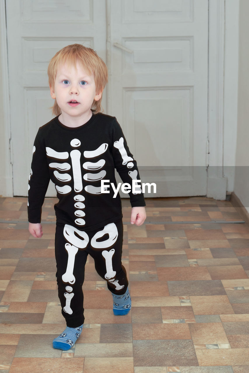 portrait of cute baby girl standing on floor at home