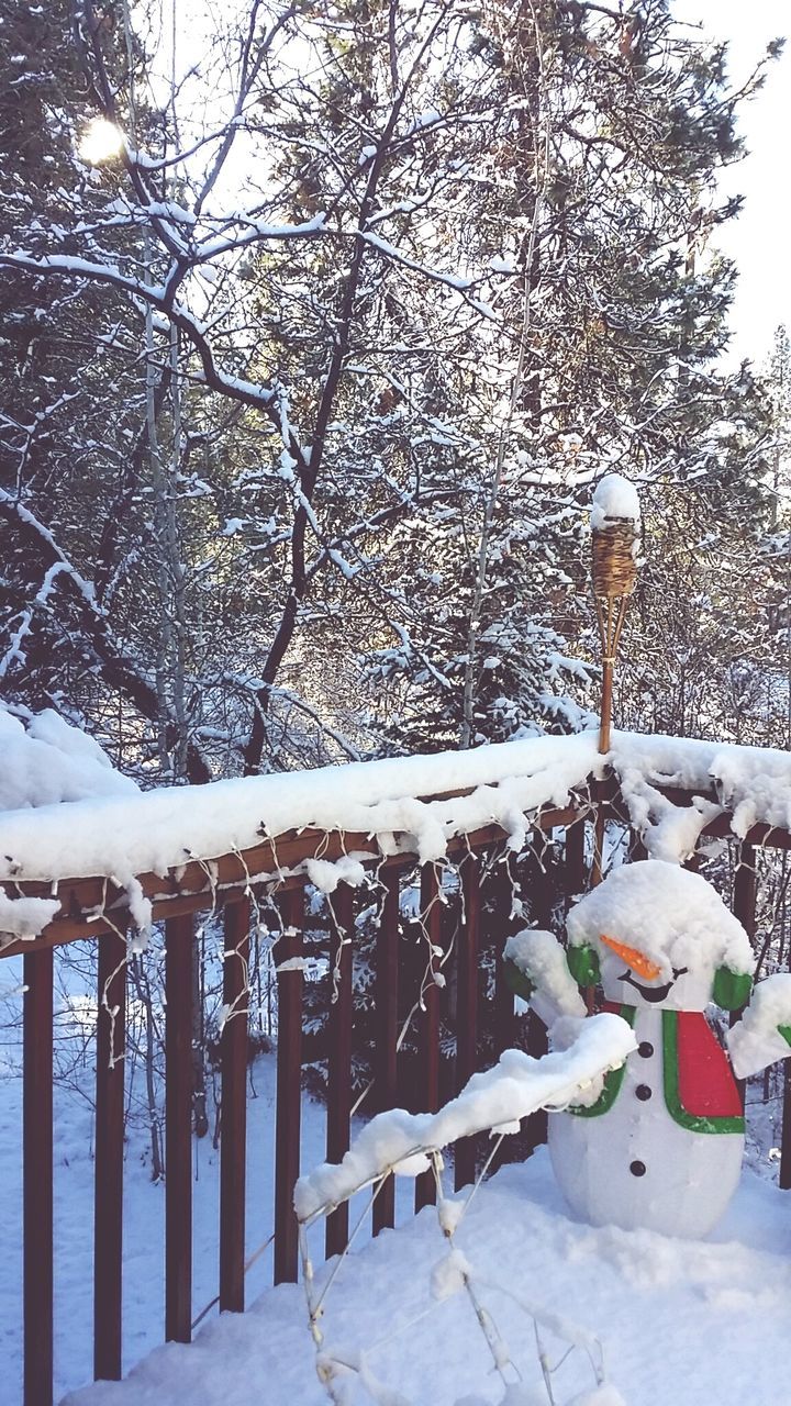 Snowman on snowcapped porch during winter