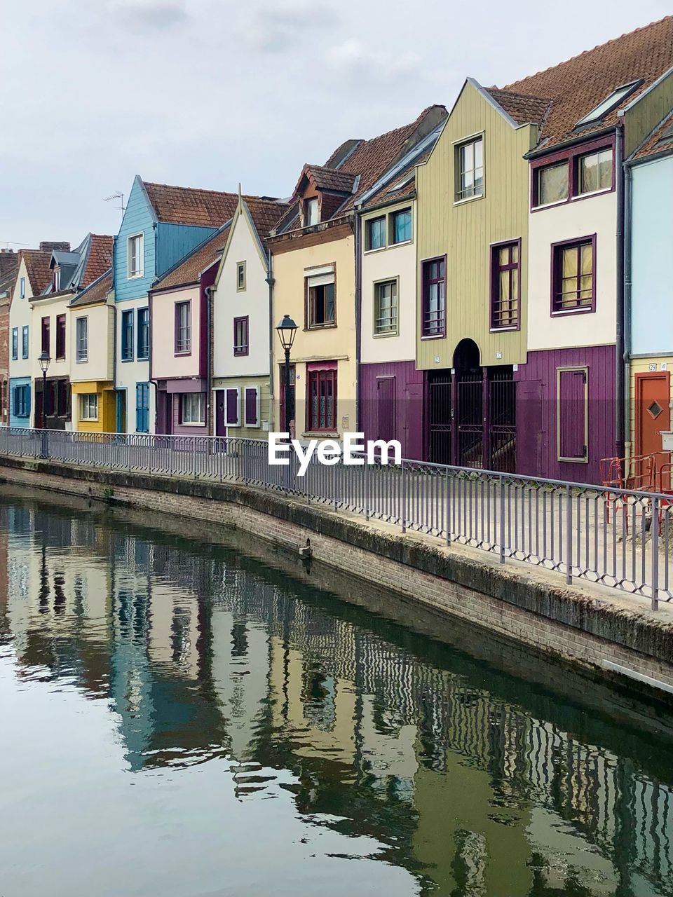 architecture, water, built structure, building exterior, building, reflection, waterway, house, town, residential district, canal, city, sky, waterfront, nature, no people, multi colored, travel destinations, estate, cloud, outdoors, window, transportation, tourism, body of water, row house, day, cityscape, home, travel, home ownership, in a row