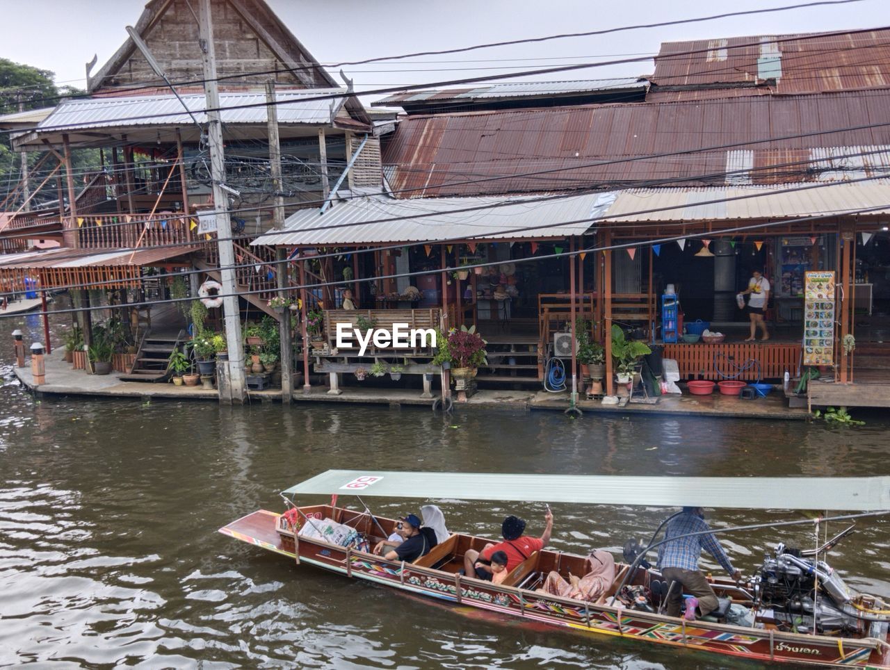 water, nautical vessel, transportation, architecture, boat, built structure, mode of transportation, building exterior, vehicle, travel, nature, group of people, boating, river, travel destinations, tourism, day, watercraft, building, waterway, stilt house, men, outdoors, adult, lifestyles, crowd, city, tradition, trip, vacation, tourist, house, large group of people