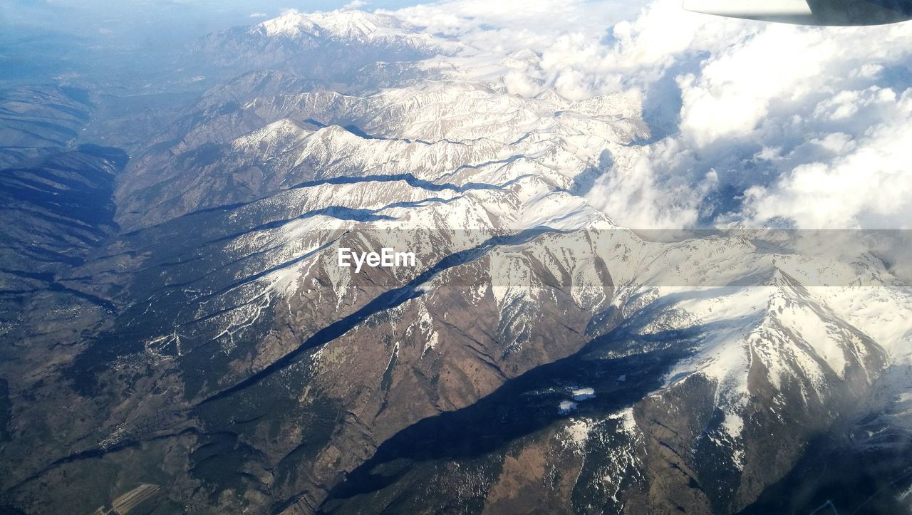 HIGH ANGLE VIEW OF SNOW COVERED MOUNTAINS