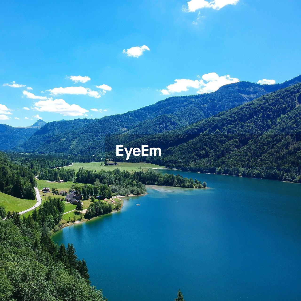 Scenic view of lake and mountains against blue sky