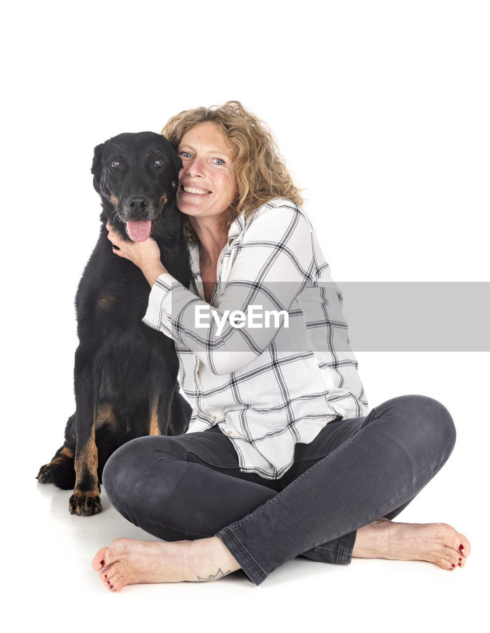 MID ADULT WOMAN WITH DOG SITTING ON WHITE BACKGROUND