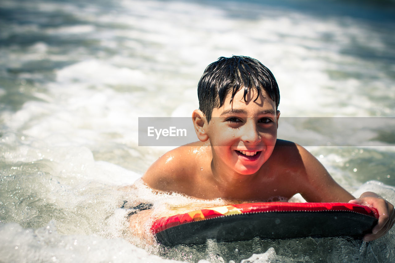 Portrait of boy bodysurfing in sea