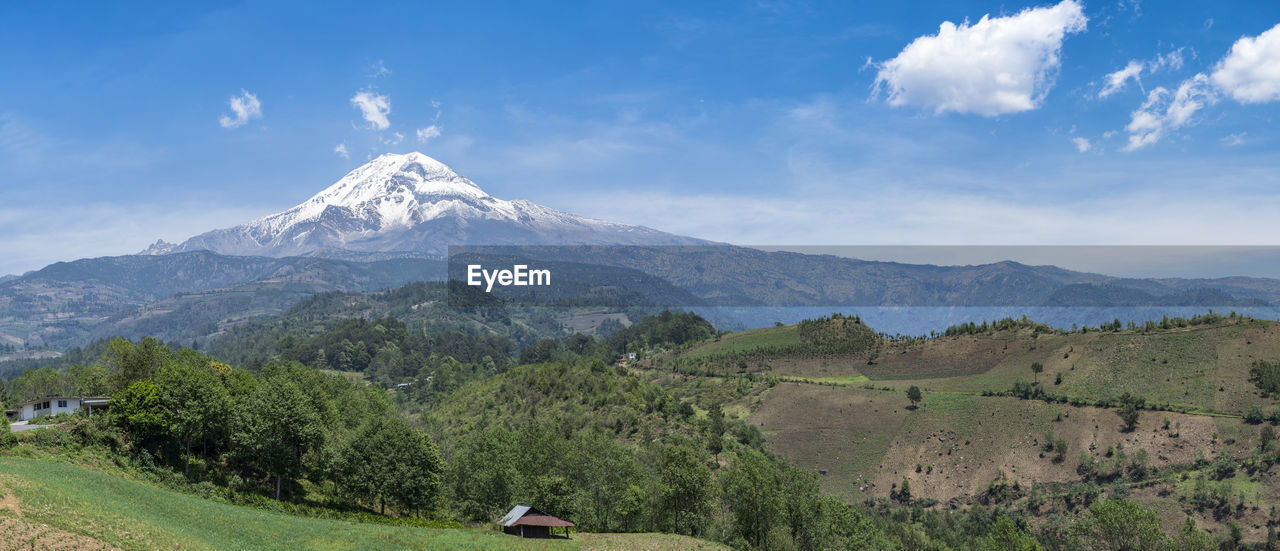 Scenic view of mountains against blue sky on sunny day