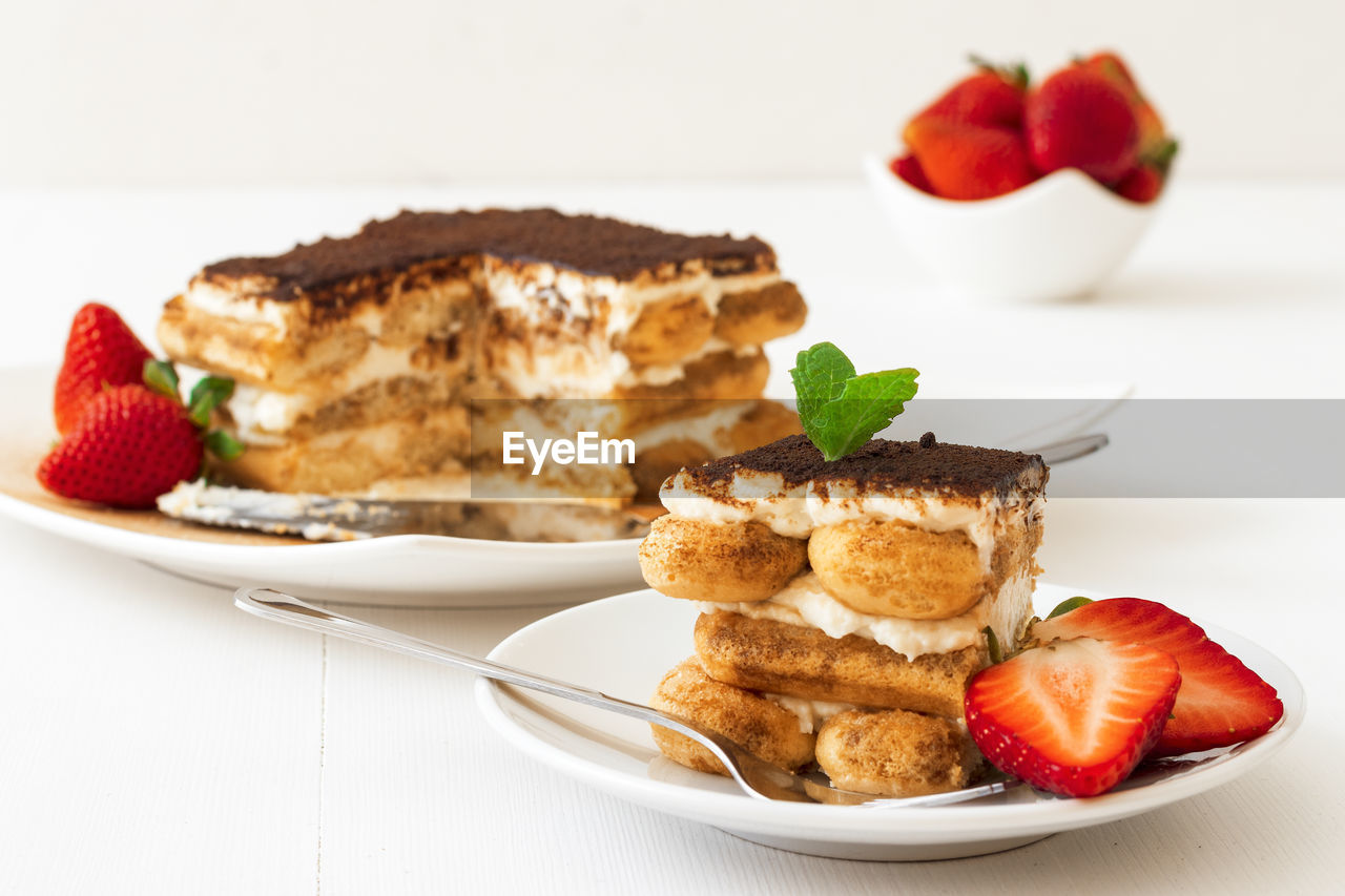 Homemade tiramisu, traditional italian no-bake cheesecake dessert with fresh strawberries