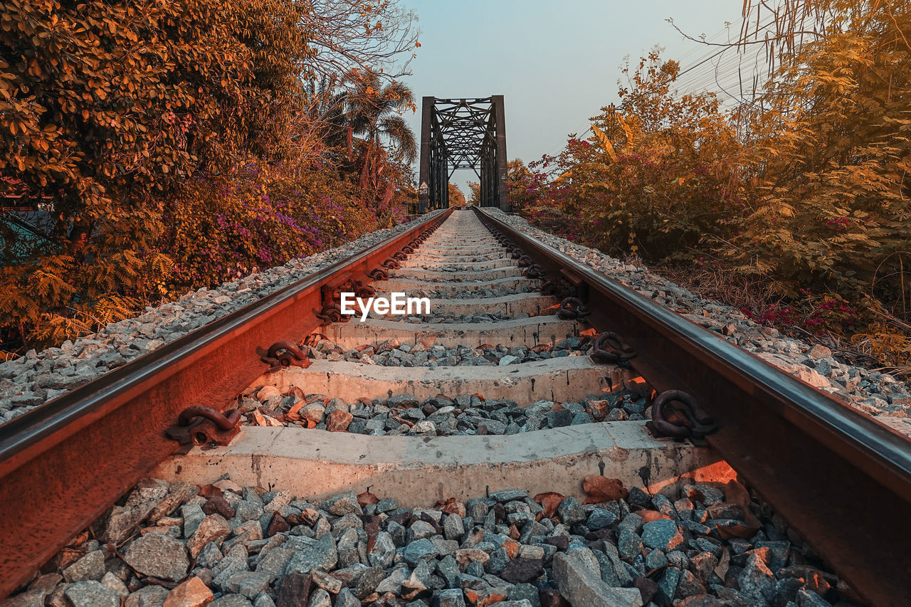 Railroad tracks with rocky tracks, looking far away to the evening sun.