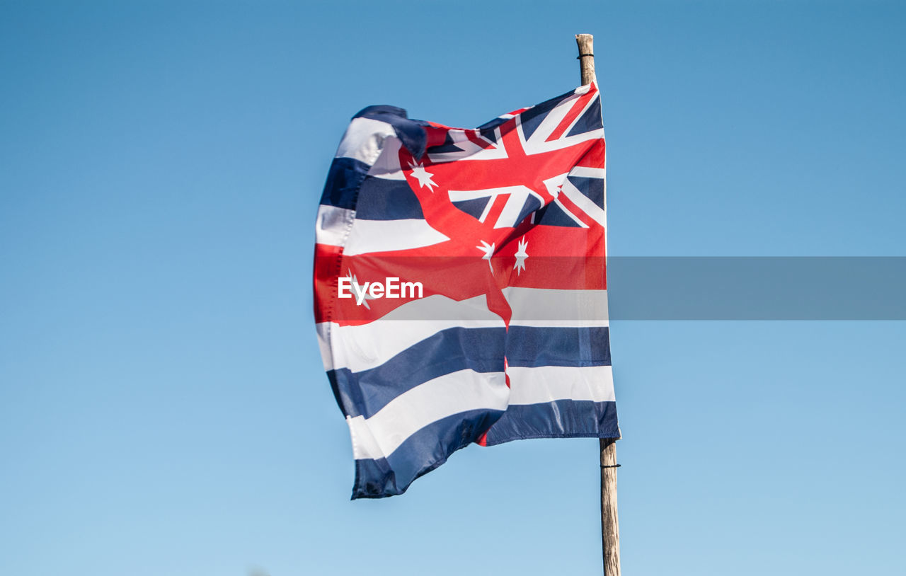 Low angle view of flag against blue sky