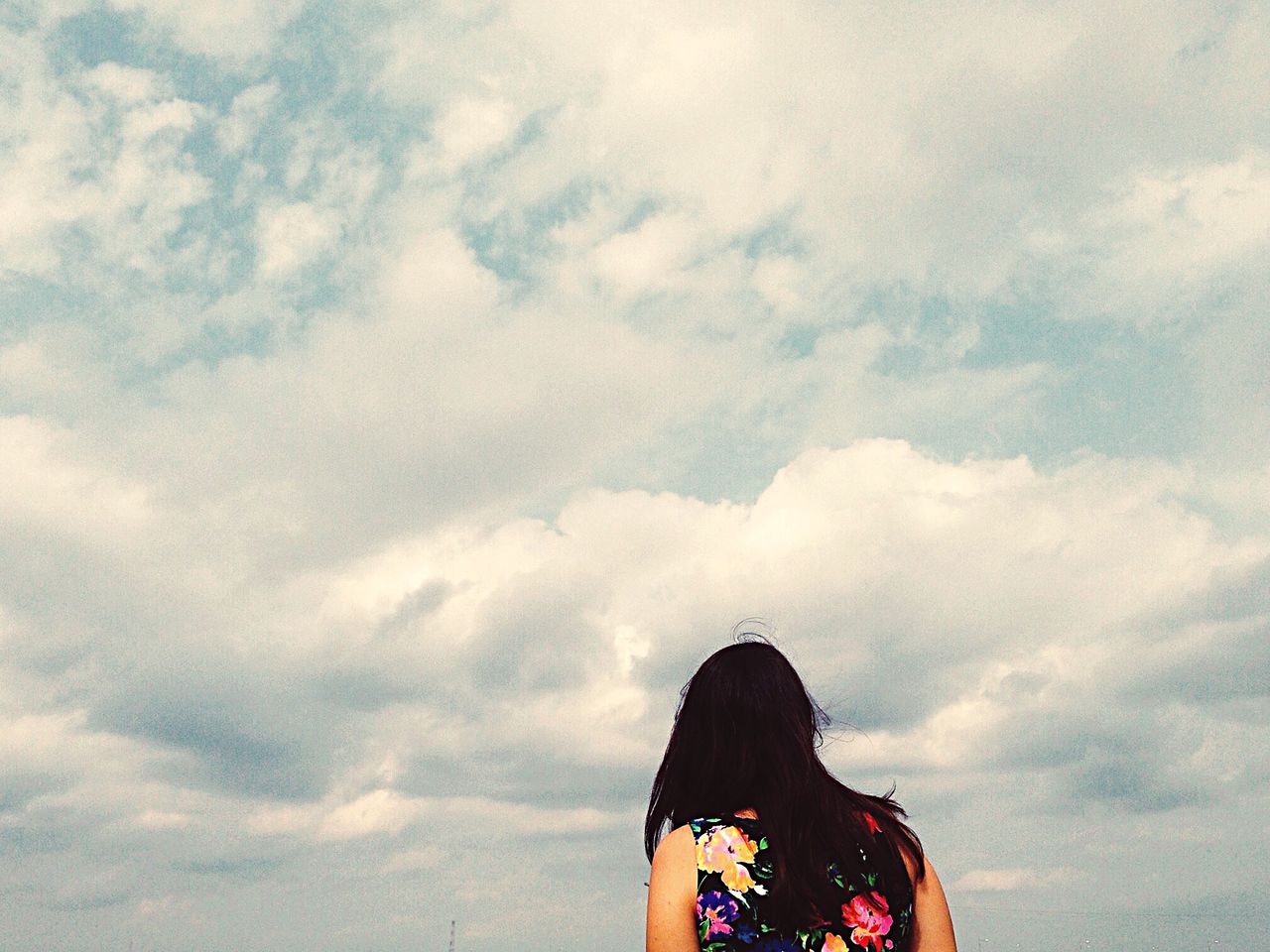 Rear view of woman against cloudy sky