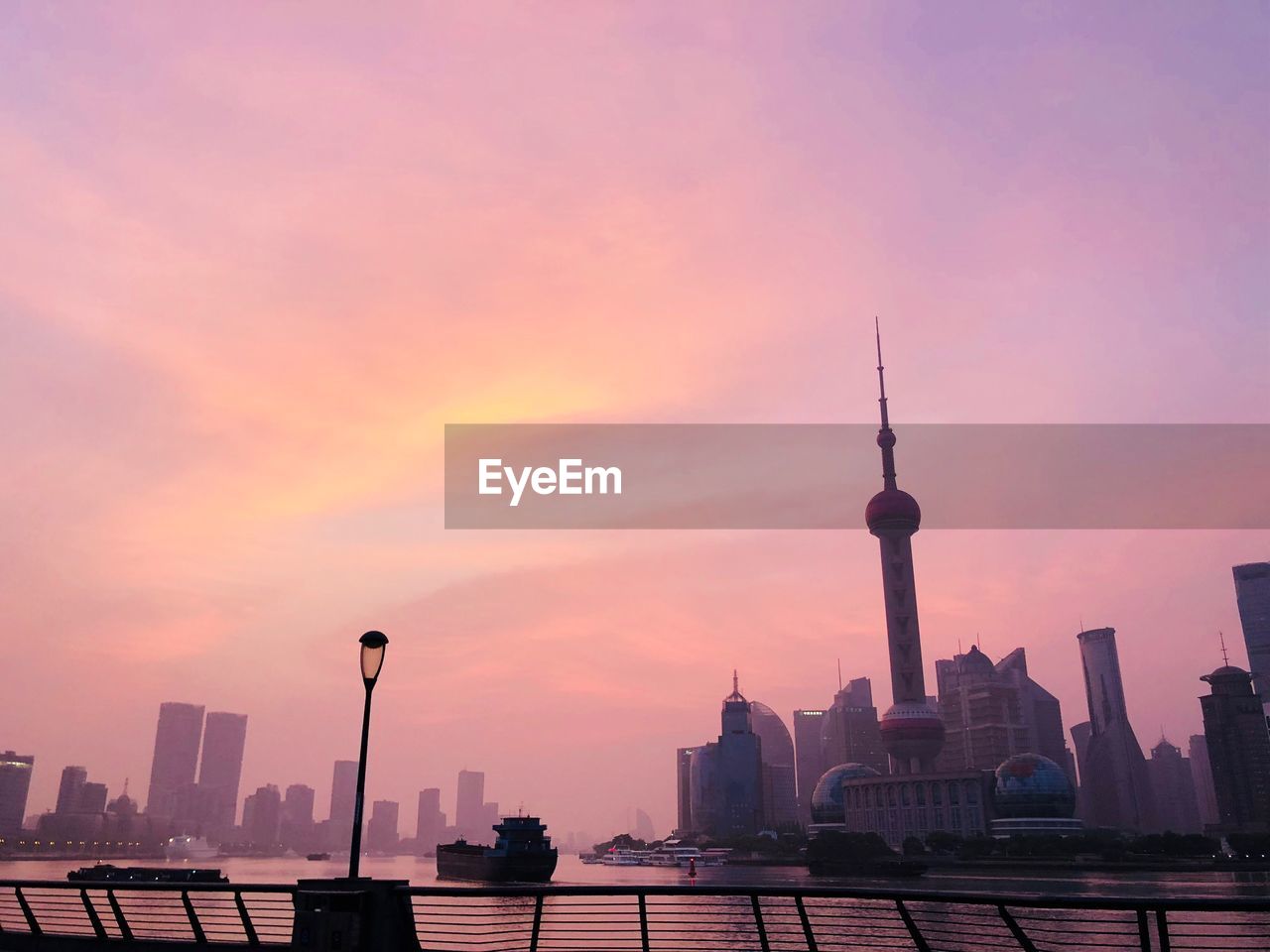 Modern buildings in city against sky during sunset