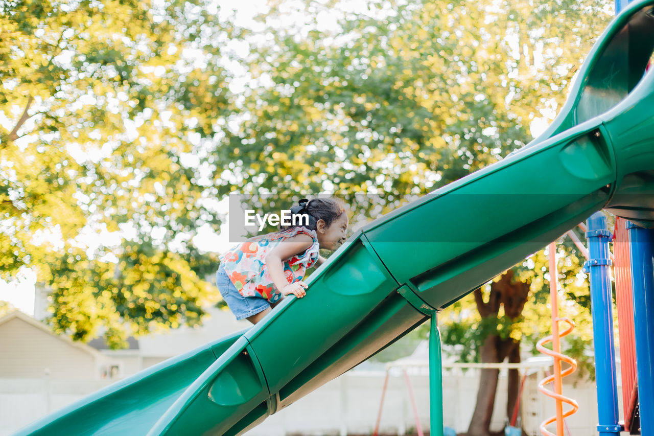 Diverse mixed race pre school age girl at park during a nice summer sunset 