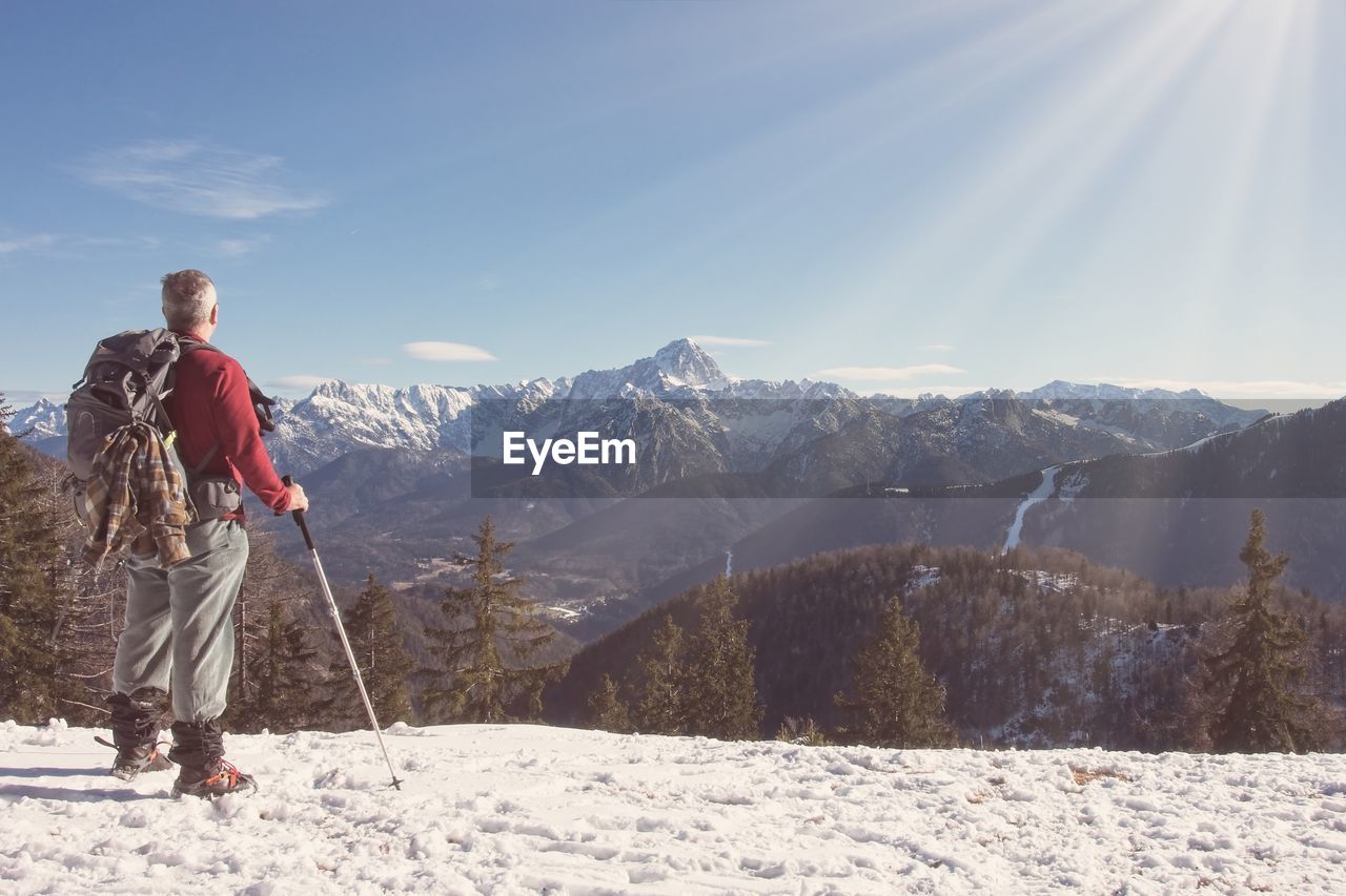 PERSON ON SNOWCAPPED MOUNTAIN AGAINST SKY