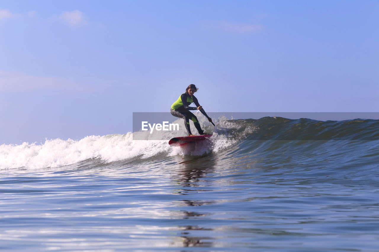 Female sup surfer on a wave