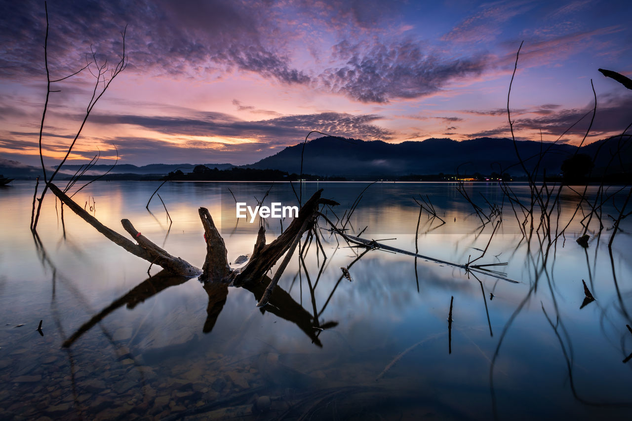 Tranquil sunrise reflection on beris lake horizon at sik, kedah darul aman