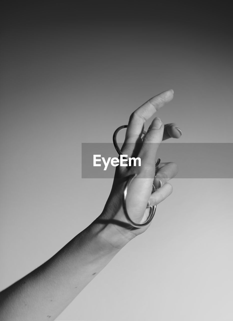 CLOSE-UP OF HANDS AGAINST WHITE BACKGROUND