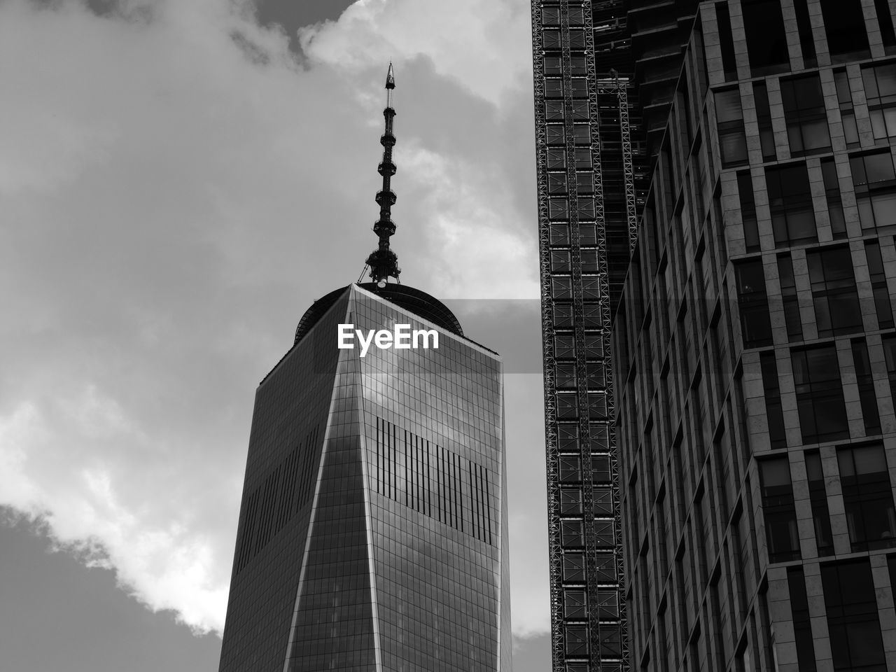 Low angle view of skyscrapers against cloudy sky