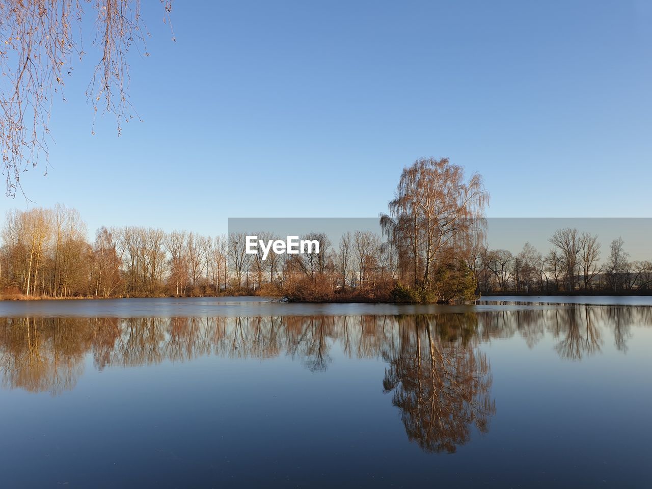 Scenic view of lake against clear blue sky