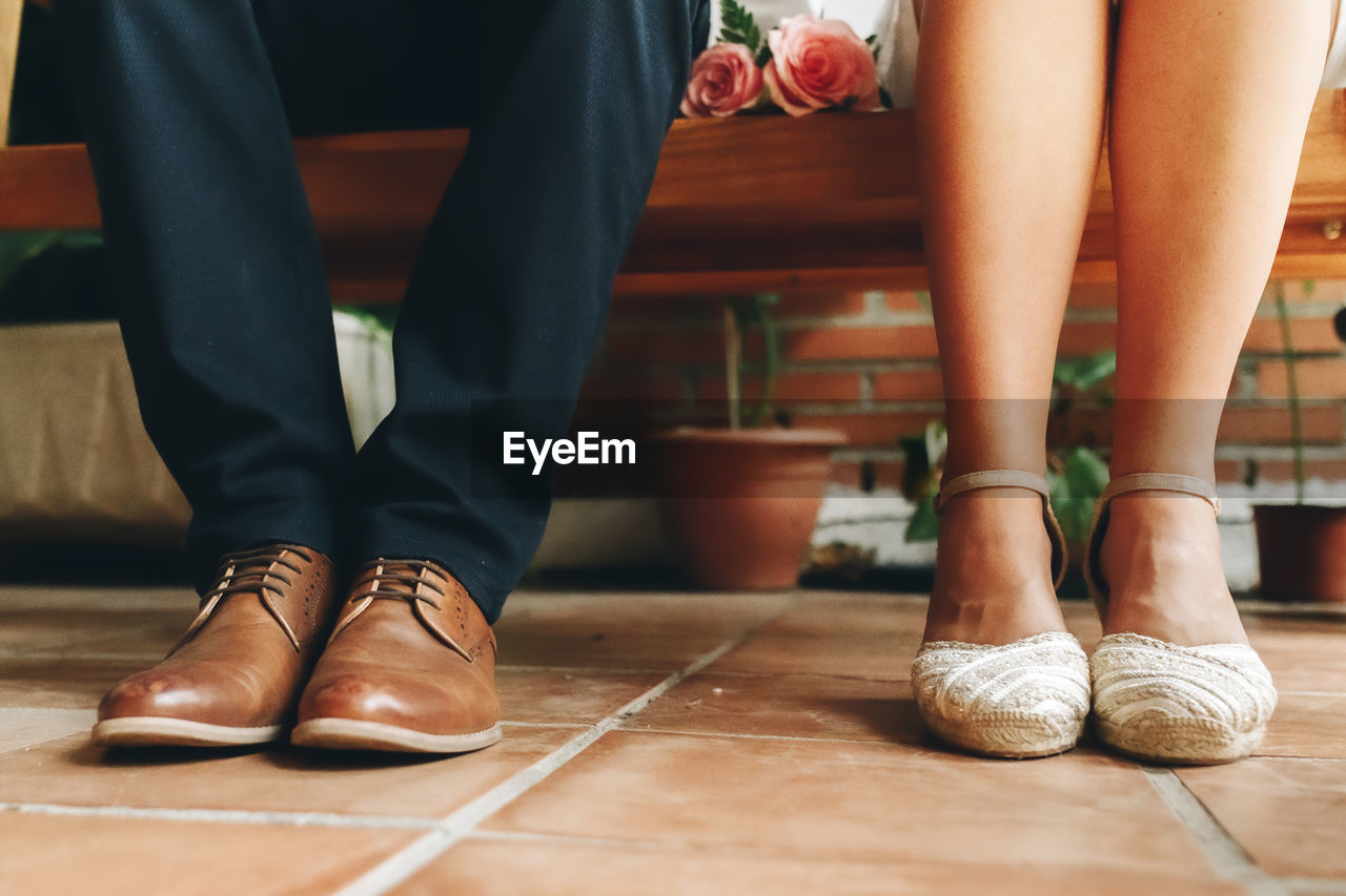 Low section of bridegroom sitting on bench