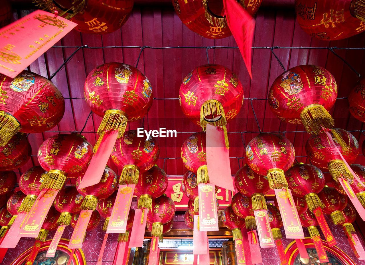 LOW ANGLE VIEW OF LANTERNS HANGING AGAINST SKY AT NIGHT